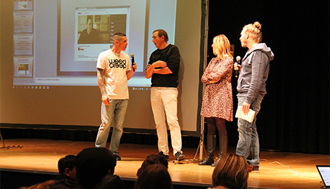 Sick und drei weitere Personen auf einer Bühne mit Präsentation im Hintergrund auf einer Leinwand